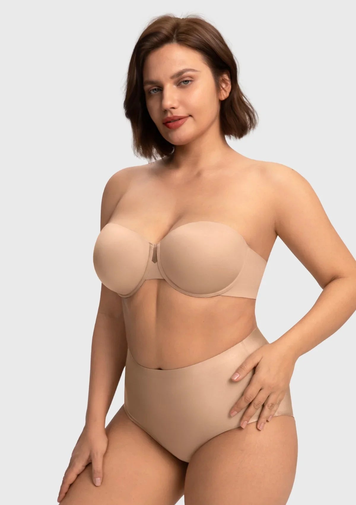 A woman stretching her arms in the almond skin stay-put strapless bra, enjoying restriction-free movement and secure containment.