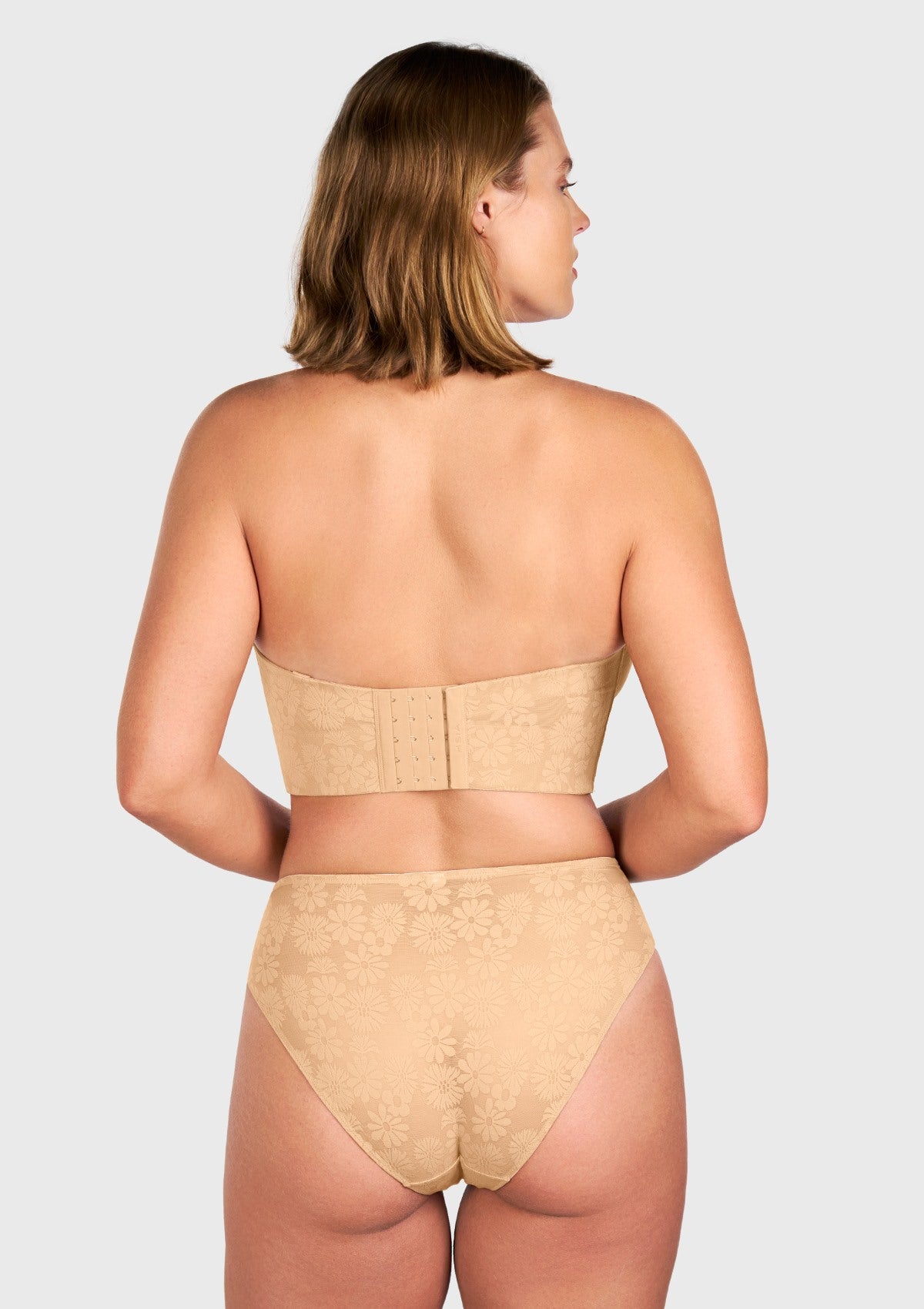 Rear view of the beige convertible strapless bra, featuring the wide, breathable mesh lining and personalized hook closure for all-day stability.