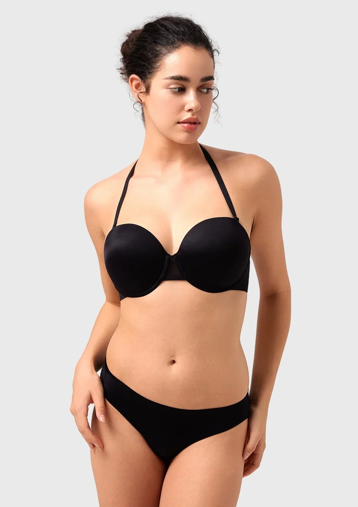 Woman raising her arms in the black convertible push-up bra, enjoying restriction-free movement and flexible, skin-friendly comfort.