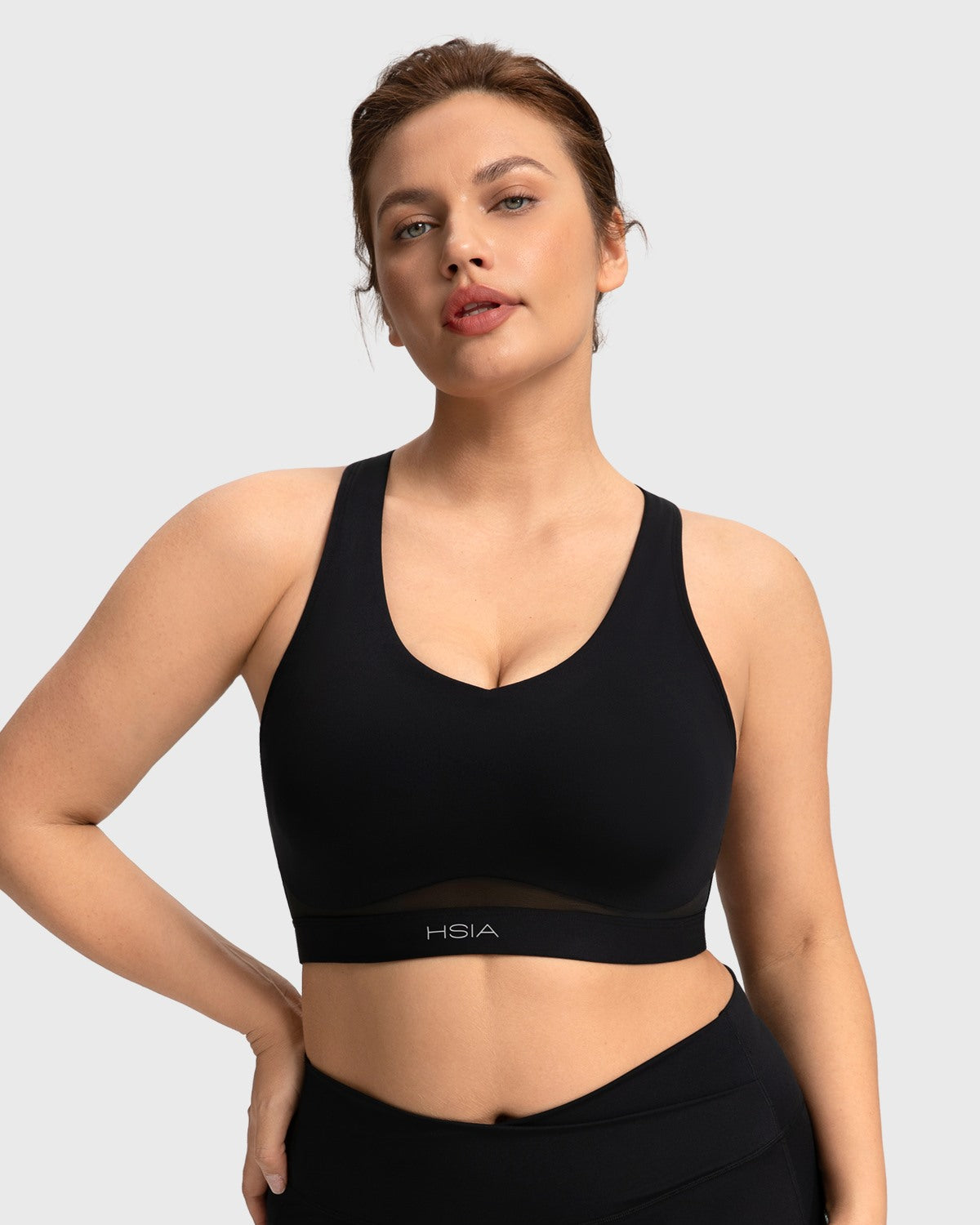 Close-up showing the high-stretch elastic band of the black Aura yoga bra for an inclusive comfortable fit