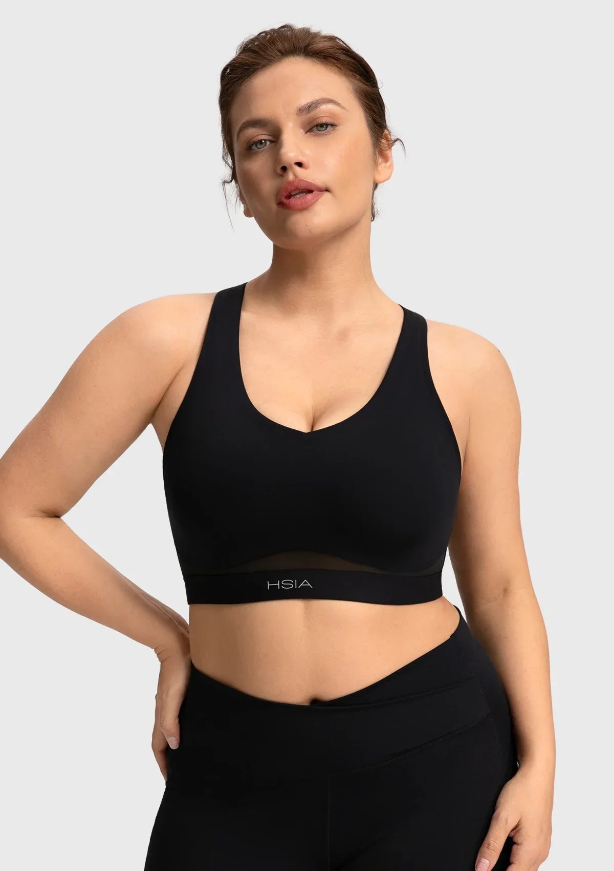 Close-up showing the high-stretch elastic band of the black Aura yoga bra for an inclusive comfortable fit