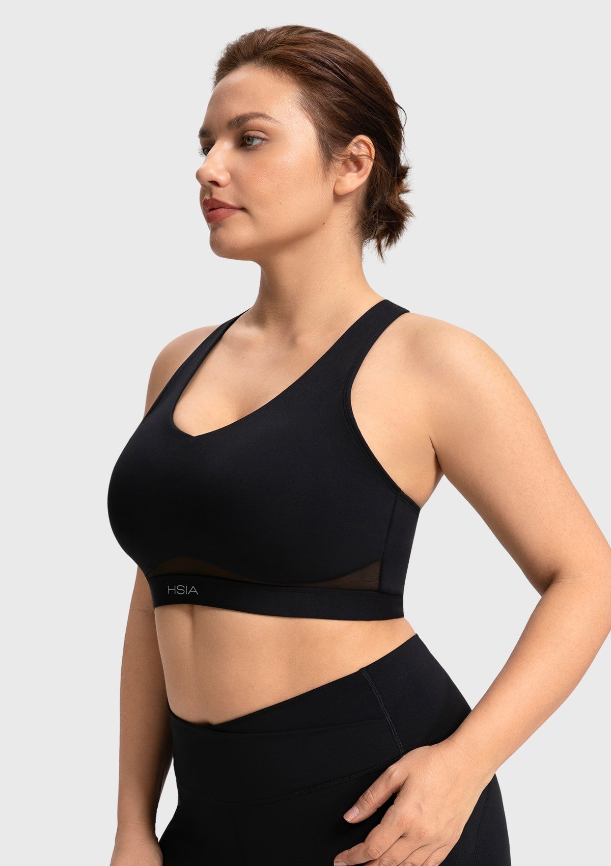 Side profile of the black Aura V-neck sports bra demonstrating full coverage and secure side support