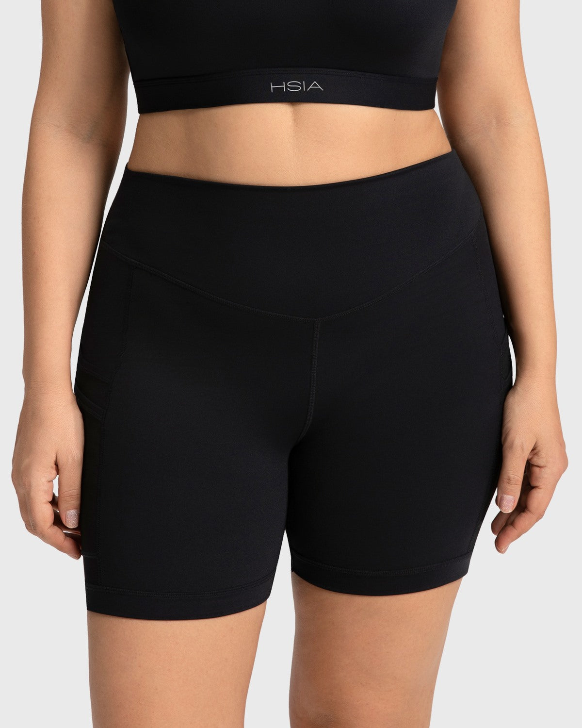 Front view of the black high waisted yoga shorts, featuring a flattering mid-thigh length that visually elongates the legs.