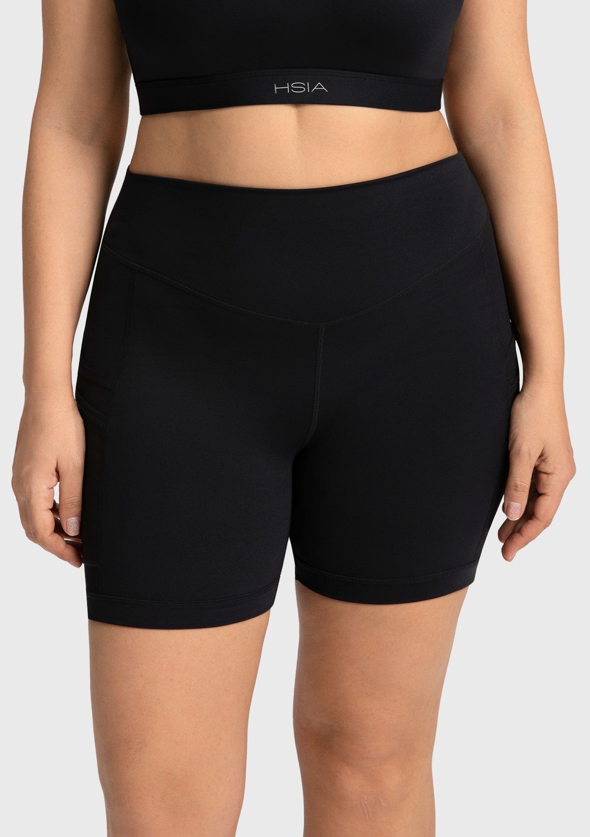Front view of the black high waisted yoga shorts, featuring a flattering mid-thigh length that visually elongates the legs.