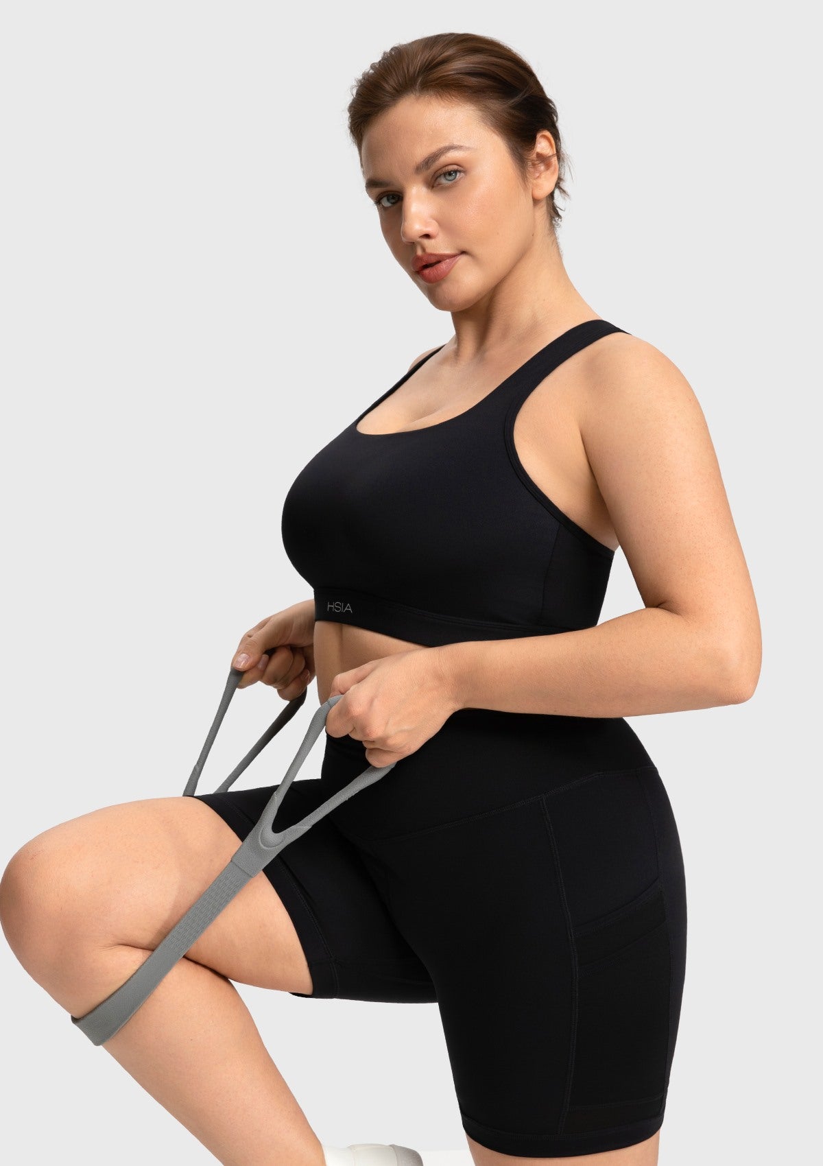 Woman working out in the black Aura strappy sports bra demonstrating unrestricted movement
