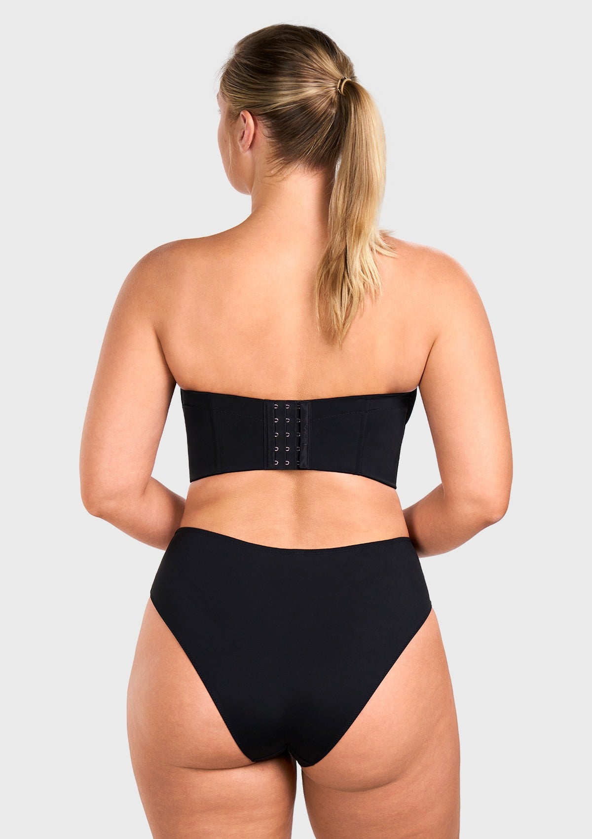 Back view of the black seamless back fat hiding bra, acting as a comfortable corset with breathable mesh wings.