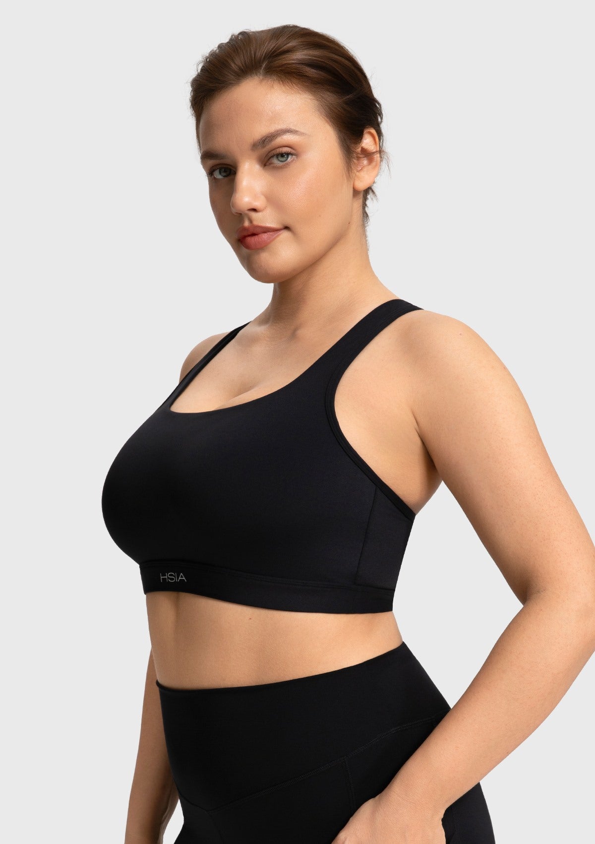 Side profile of the black Aura workout bra showing secure side support and double straps