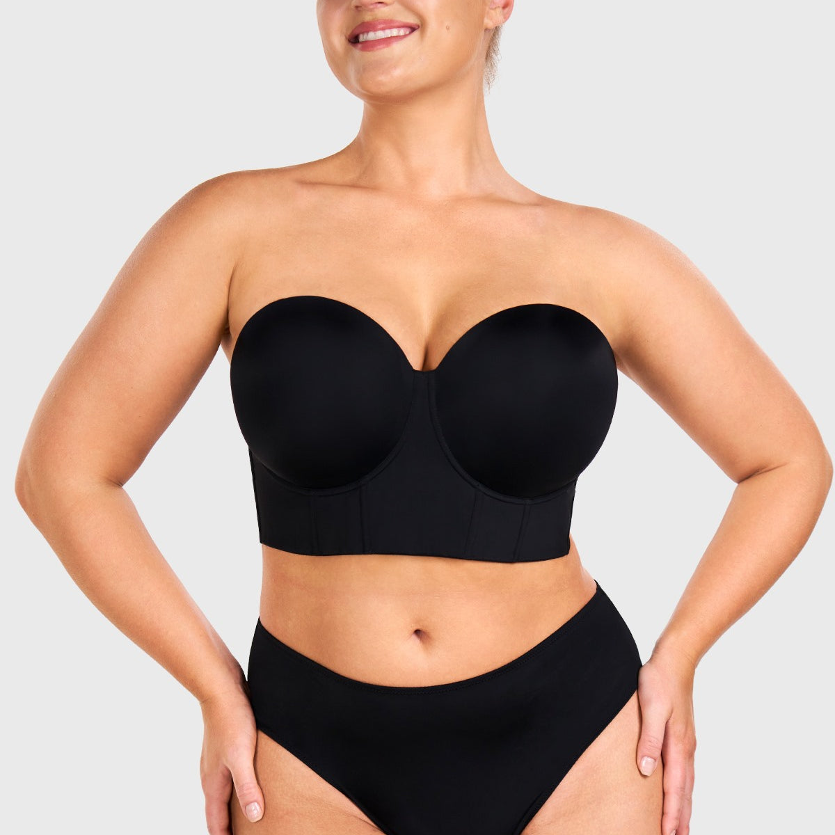 Woman wearing the black highly supportive strapless bra for large chest, enjoying gravity-defying lift and containment.