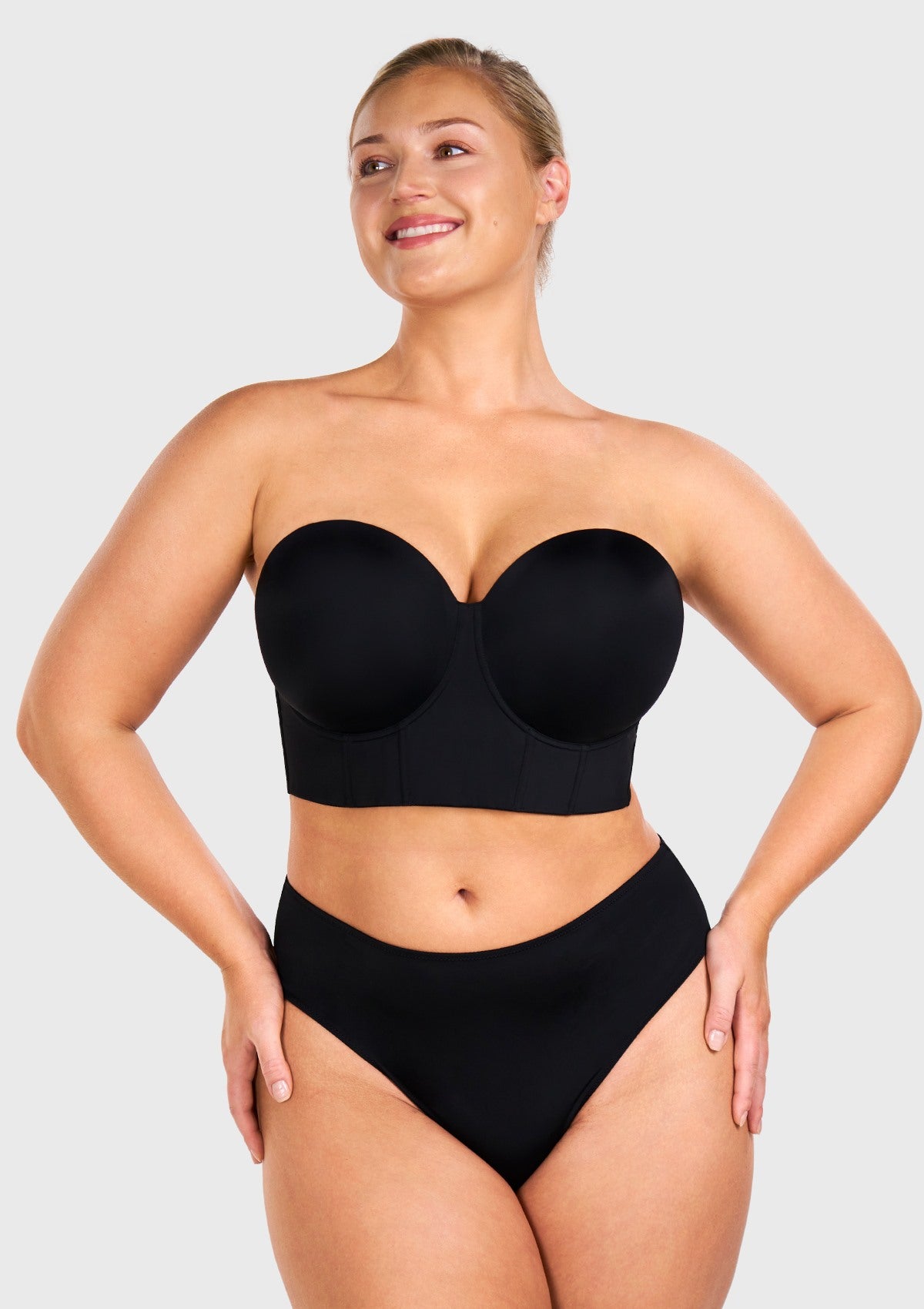 Woman wearing the black highly supportive strapless bra for large chest, enjoying gravity-defying lift and containment.
