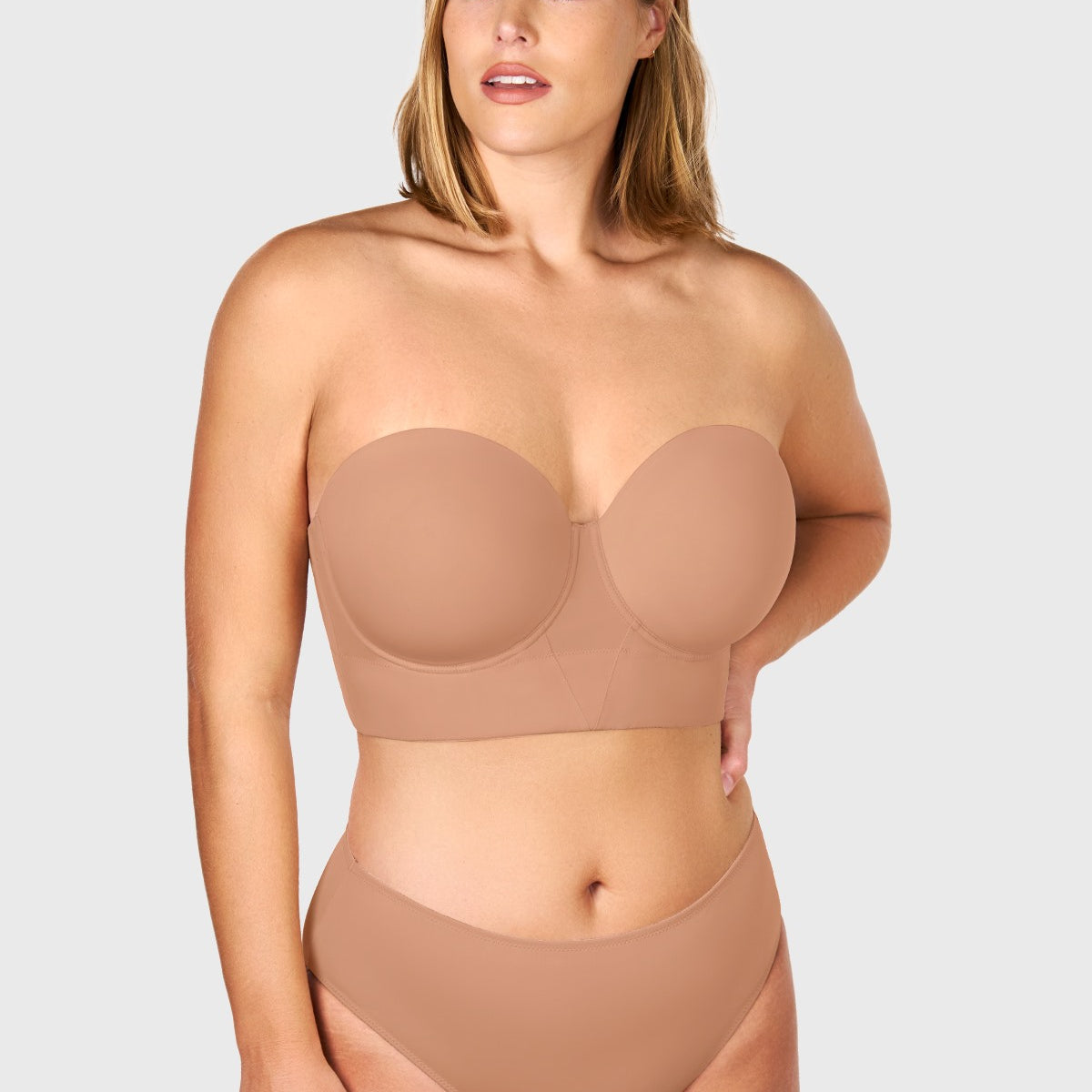 Confident woman wearing the dark beige lightly padded strapless bra, showcasing the secure, anti-slip lift designed for full-busted figures.