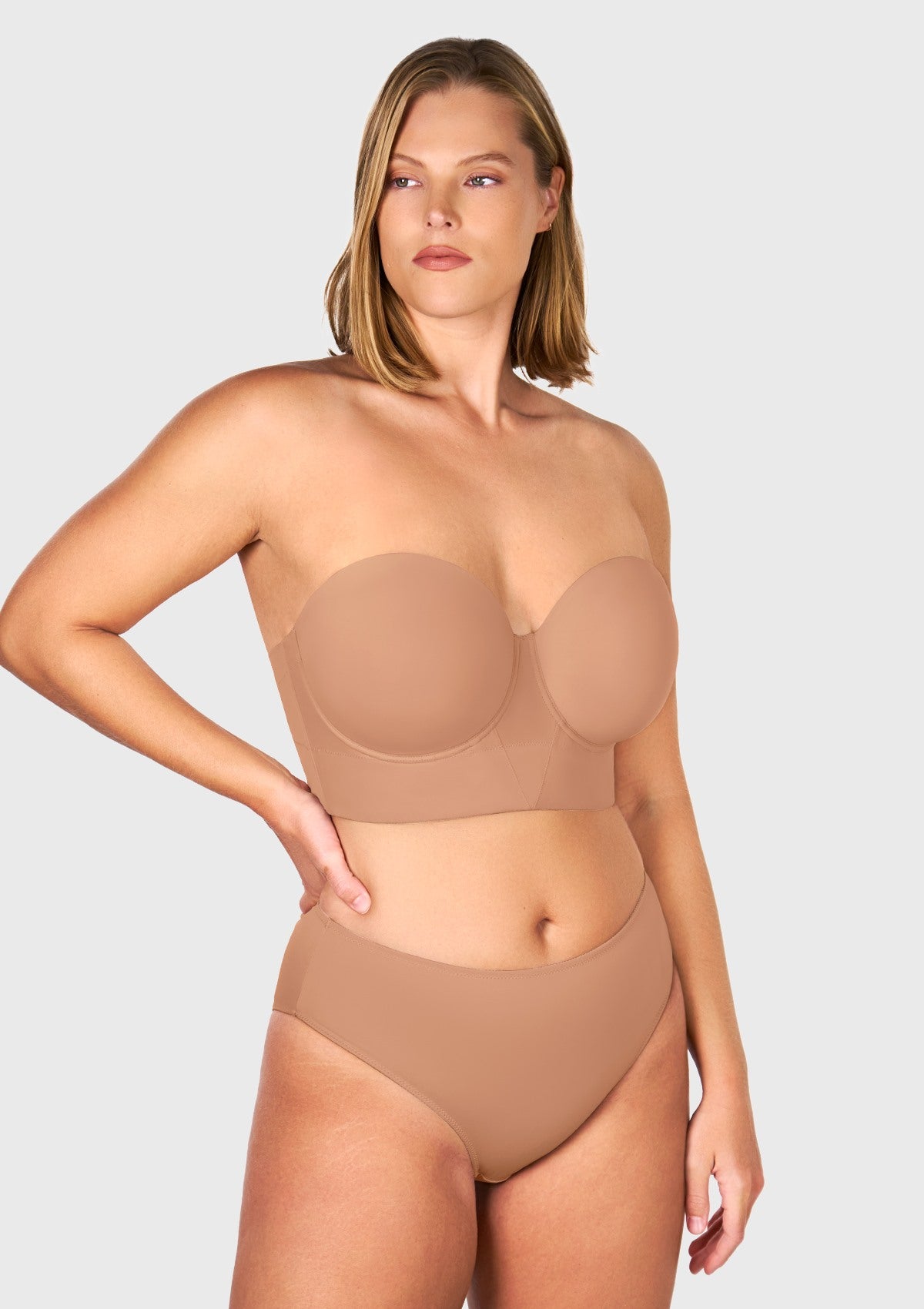 Front view of the dark beige longline strapless balconette bra, offering a flawless, invisible nude fit for medium skin tones under any outfit.