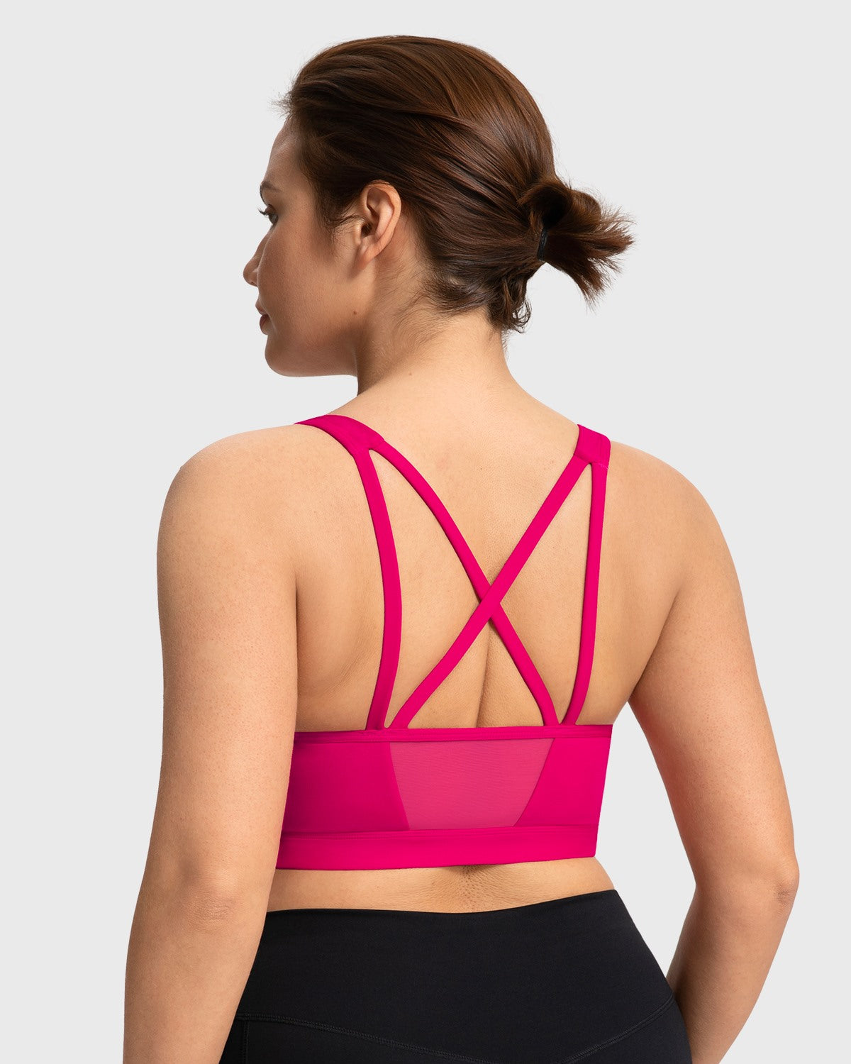 Back view featuring the double criss-cross straps and back mesh splicing on the dragon fruit pink yoga bra