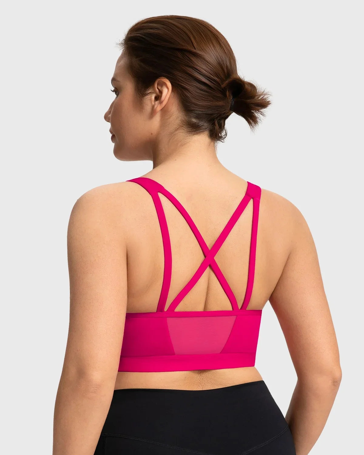 Back view featuring the double criss-cross straps and back mesh splicing on the dragon fruit pink yoga bra