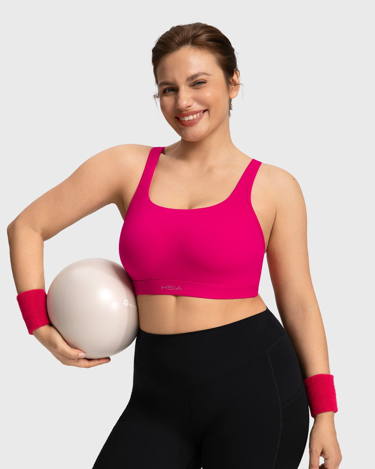 Active woman stretching in the dragon fruit pink Aura sports bra showing fluid mobility