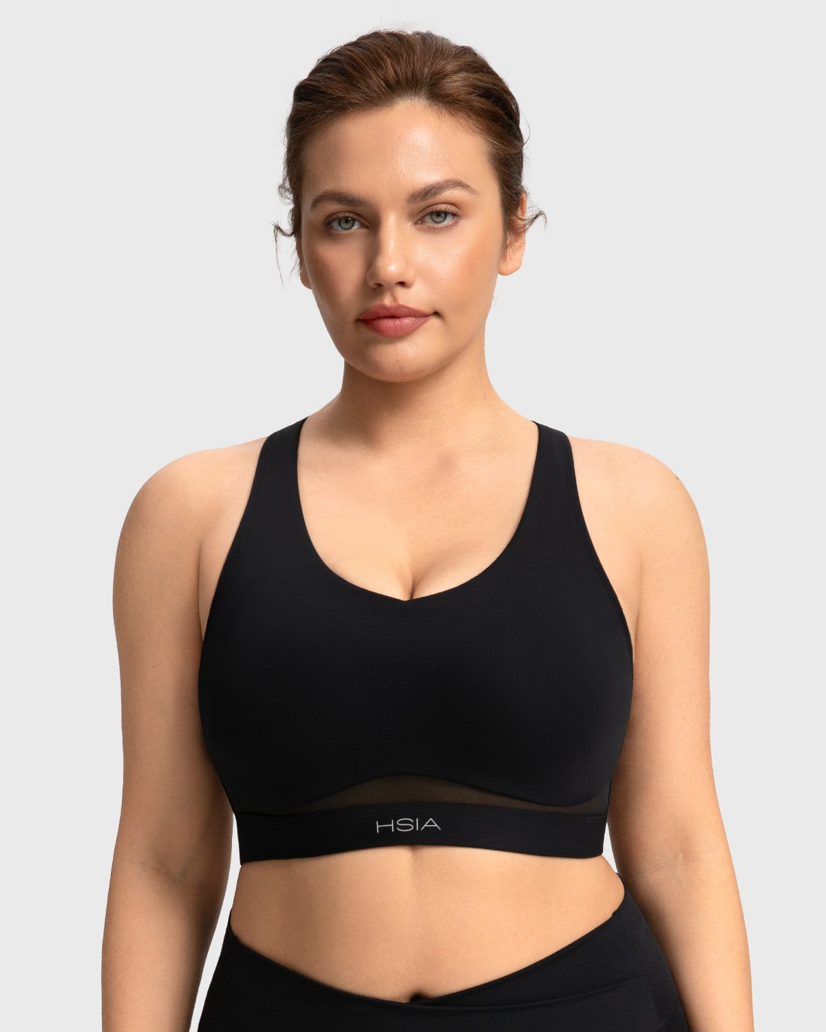 Front view of woman wearing the black Aura V-neck medium impact sports bra FYT0224