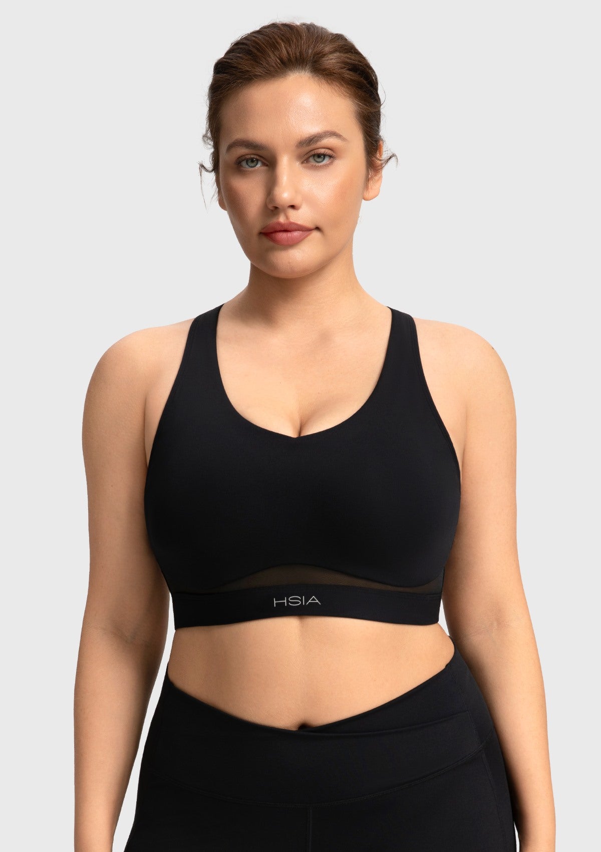Front view of woman wearing the black Aura V-neck medium impact sports bra FYT0224