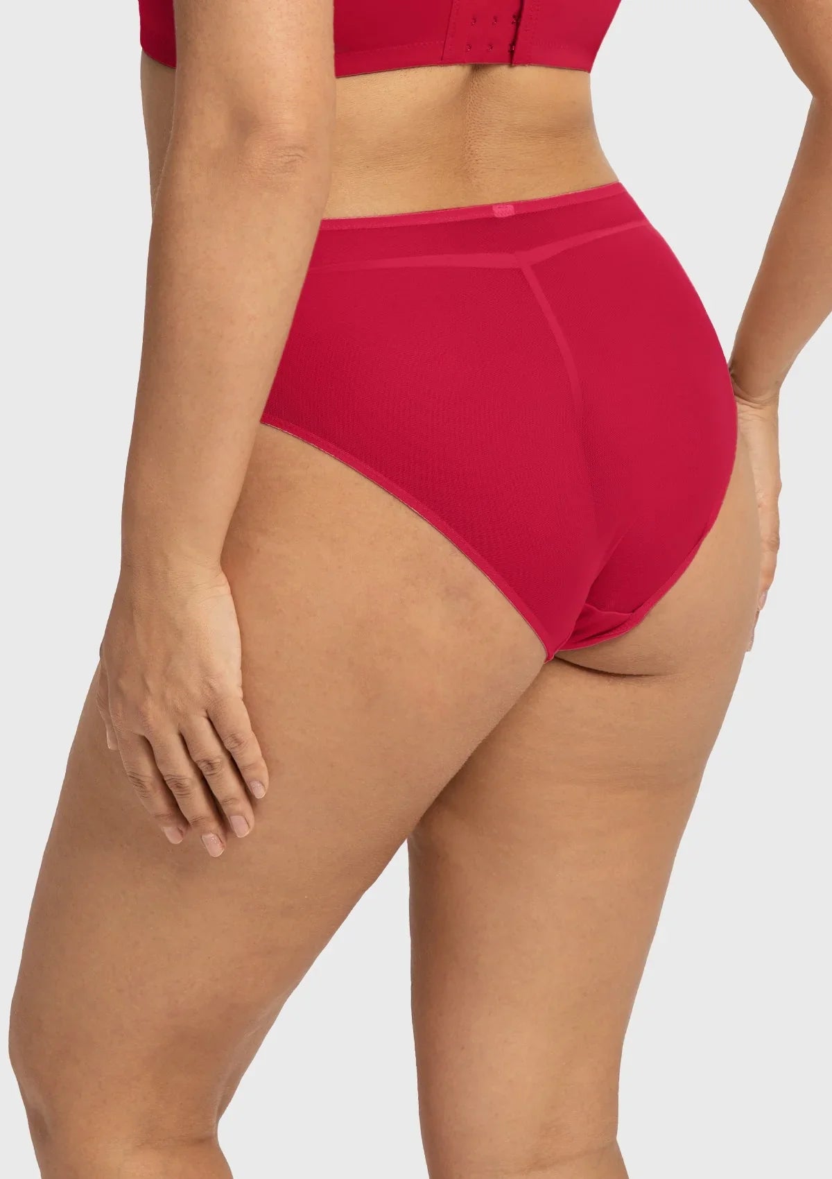 Side profile of model wearing the Coral Red Dahlia high waist underwear, showing off the flattering silhouette and premium stretchy fabrics.