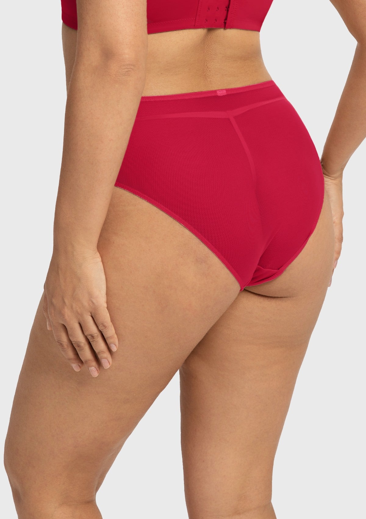 Side profile of model wearing the Coral Red Dahlia high waist underwear, showing off the flattering silhouette and premium stretchy fabrics.