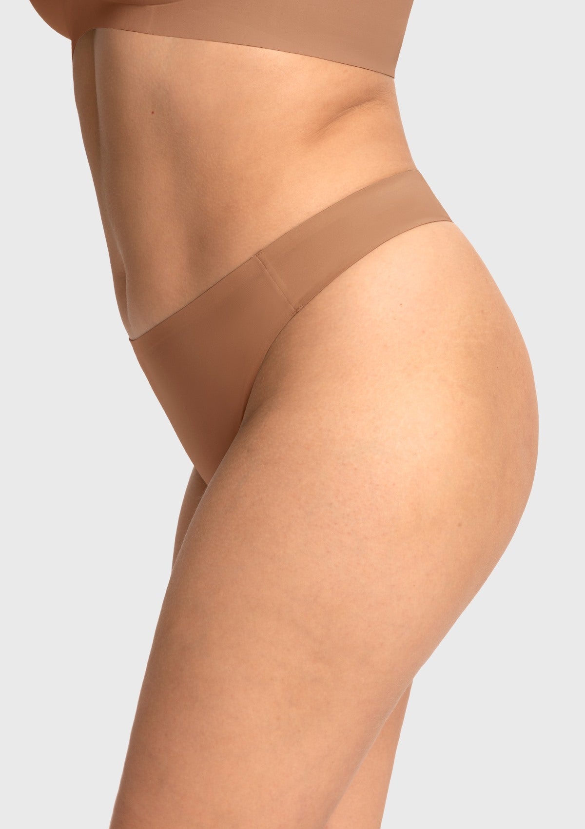 Side profile of the Coffee brown skin-friendly thong, highlighting the comfortable mid-rise cut that supports the hips and lower abdomen.