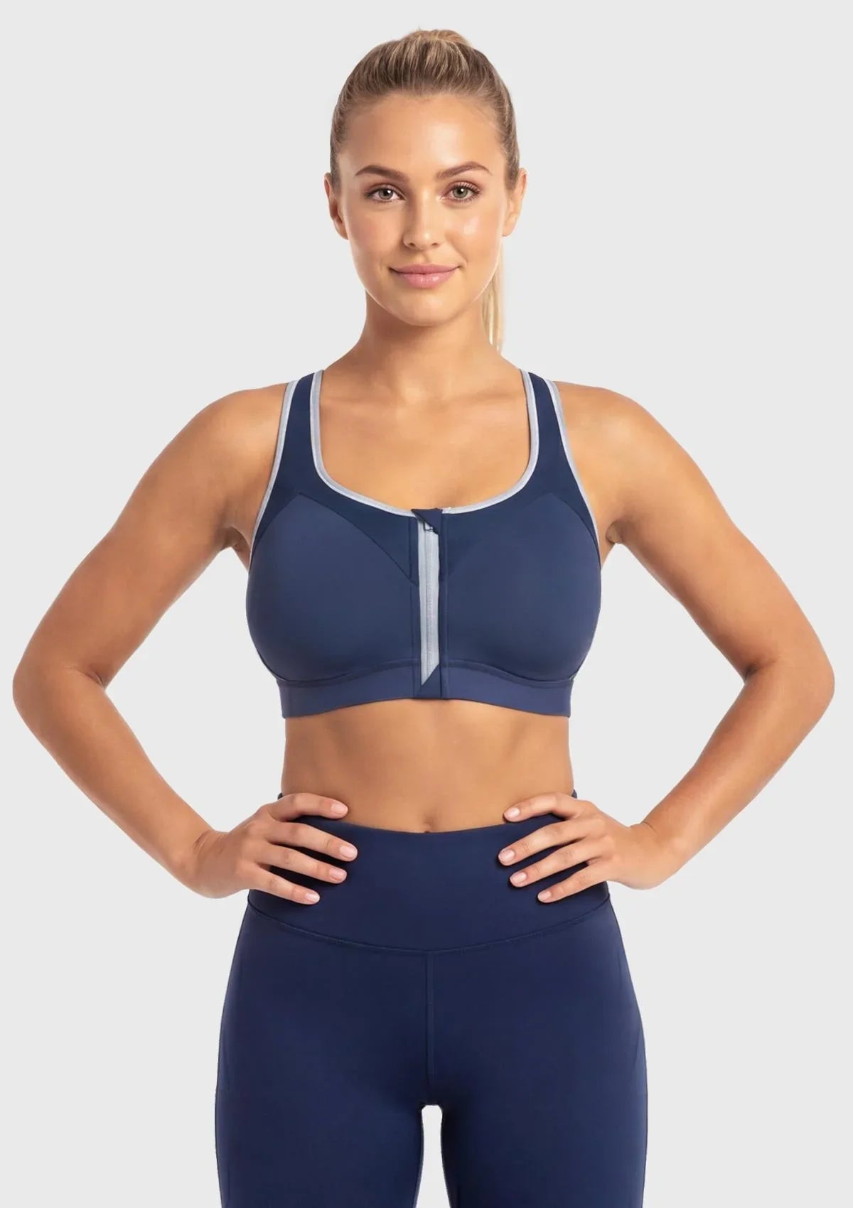 Front view of model wearing the Dark Blue HSIA Speed Race plus size front zip sports bra, featuring a secure auto-lock zipper for high-impact workouts.