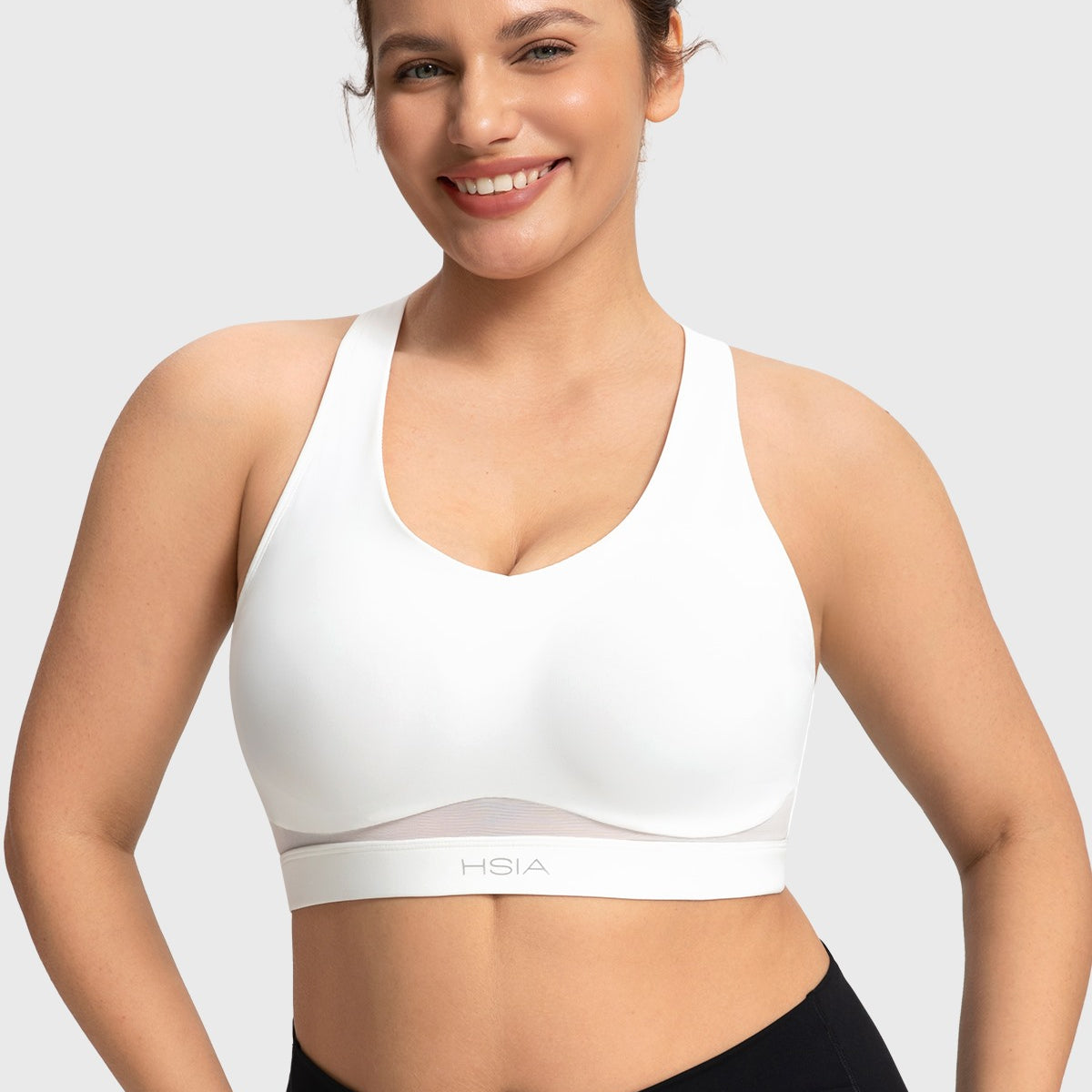 Front view of woman wearing the white Aura V-neck medium impact sports bra FYT0224