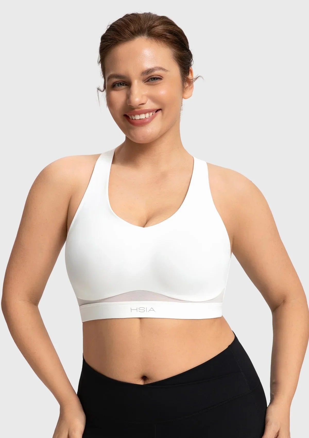 Front view of woman wearing the white Aura V-neck medium impact sports bra FYT0224