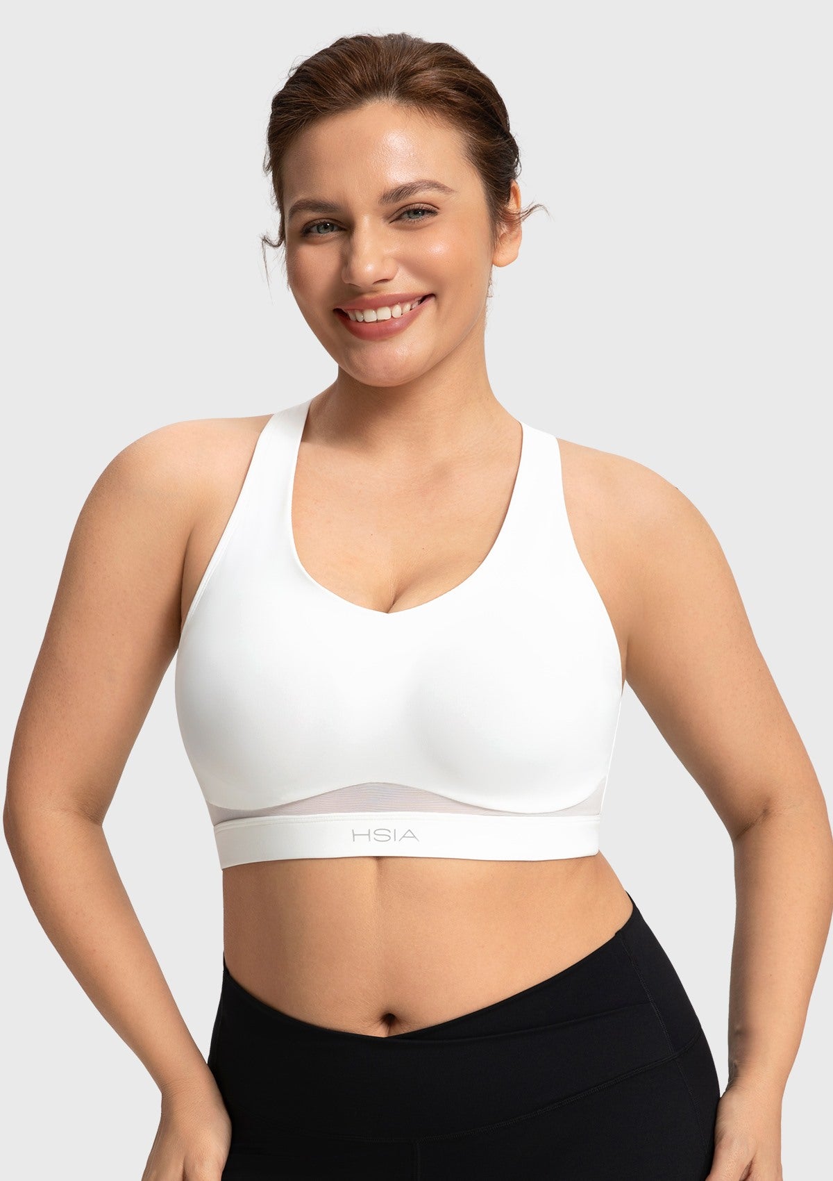 Front view of woman wearing the white Aura V-neck medium impact sports bra FYT0224