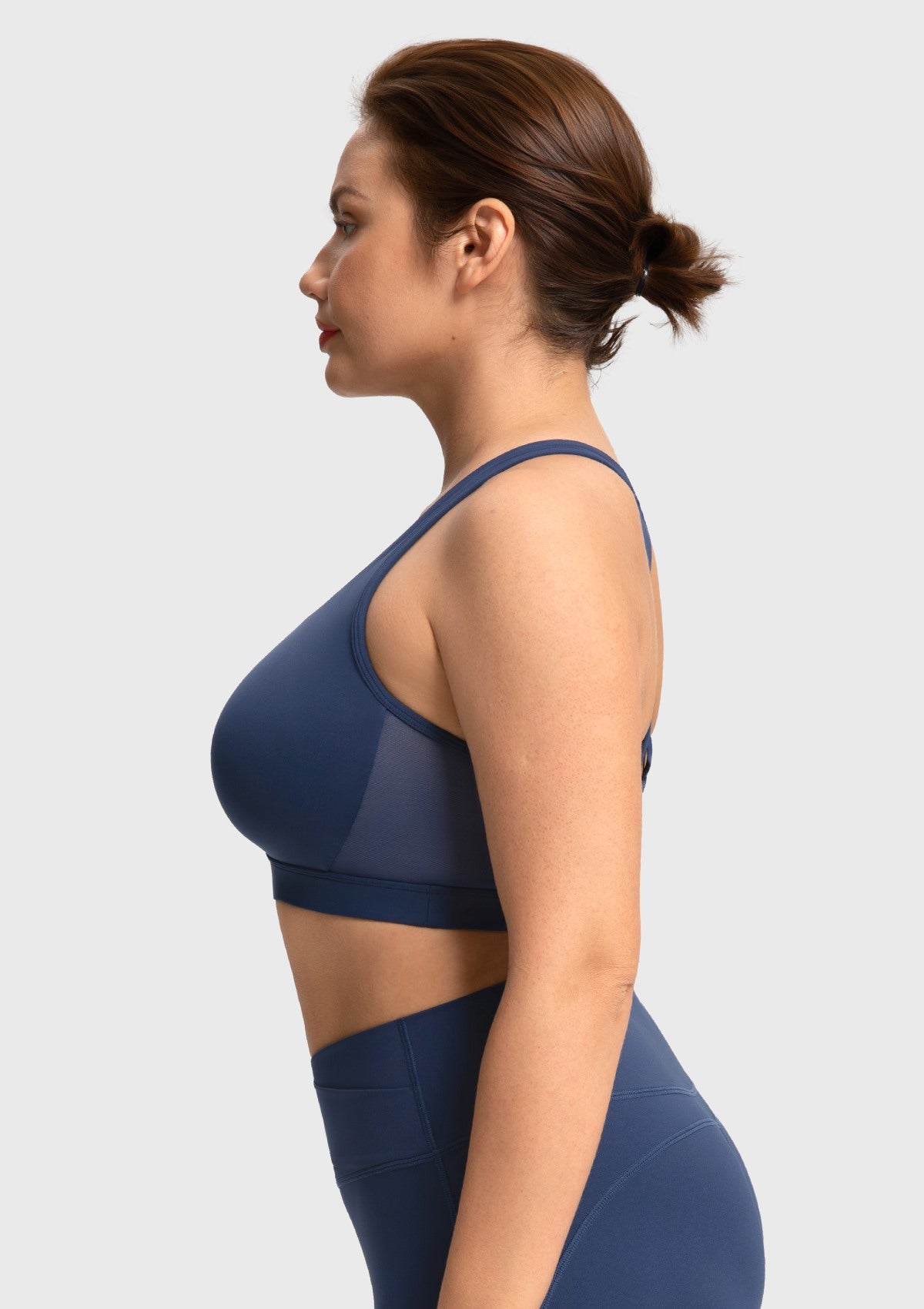 Side profile of the navy workout bra highlighting ventilating mesh side panels