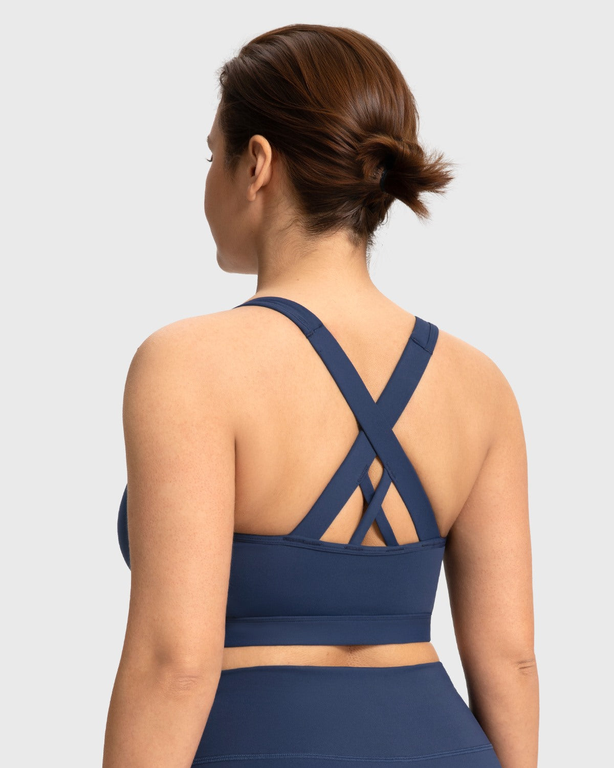 Back view of the navy blue yoga bra featuring strappy criss-cross design for maximum mobility