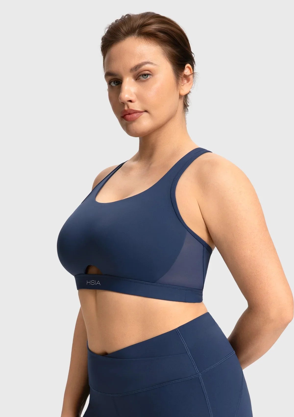 Navy blue medium impact yoga top showing flattering front cutout and full coverage fit