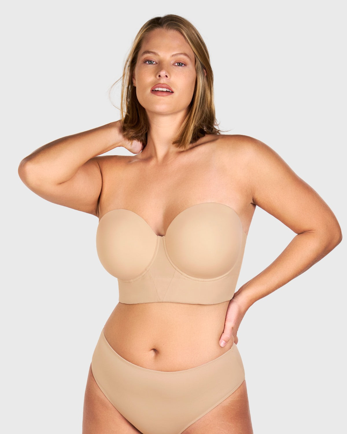 Confident woman wearing the most comfortable strapless bra that stays up, featuring an advanced 8-bone support system.