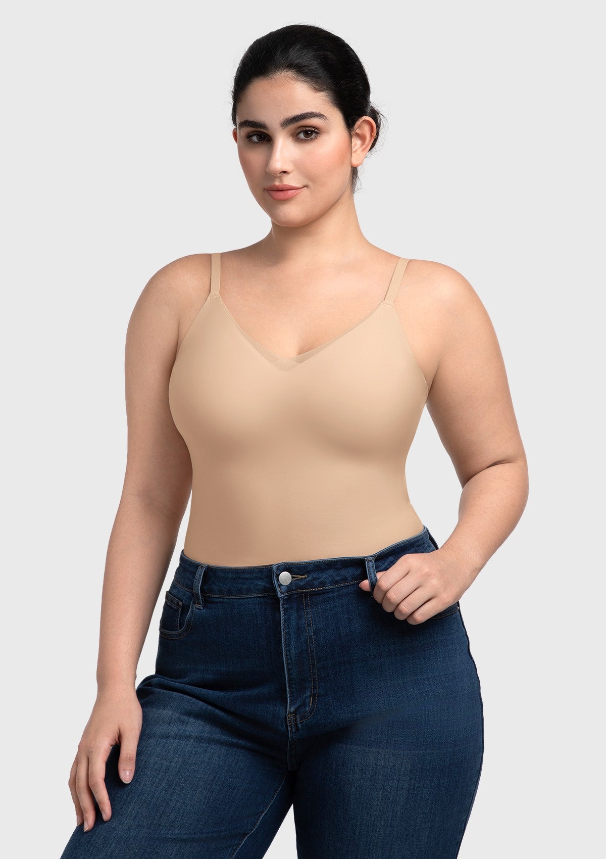 Model wearing the nude seamless tank top paired with casual trousers, illustrating its versatility as both supportive shapewear and stylish outerwear.