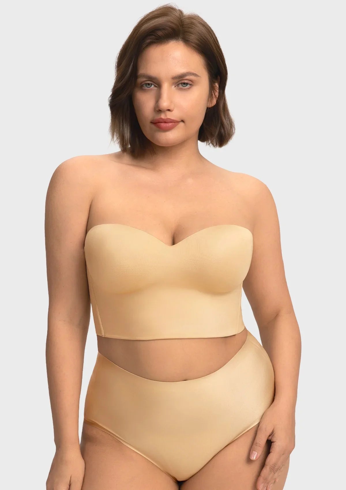 A confident woman wearing the nude supportive longline corset bra, styled effortlessly as an elegant standalone top.