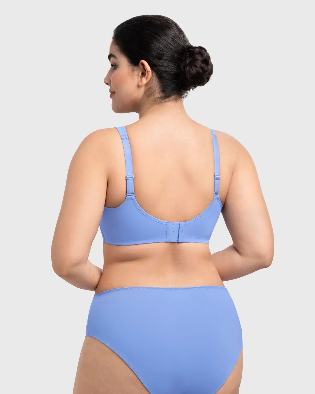 Rear view of the sky blue seamless back smoothing bra, designed with laser-cut edges to remain completely invisible under silk blouses.