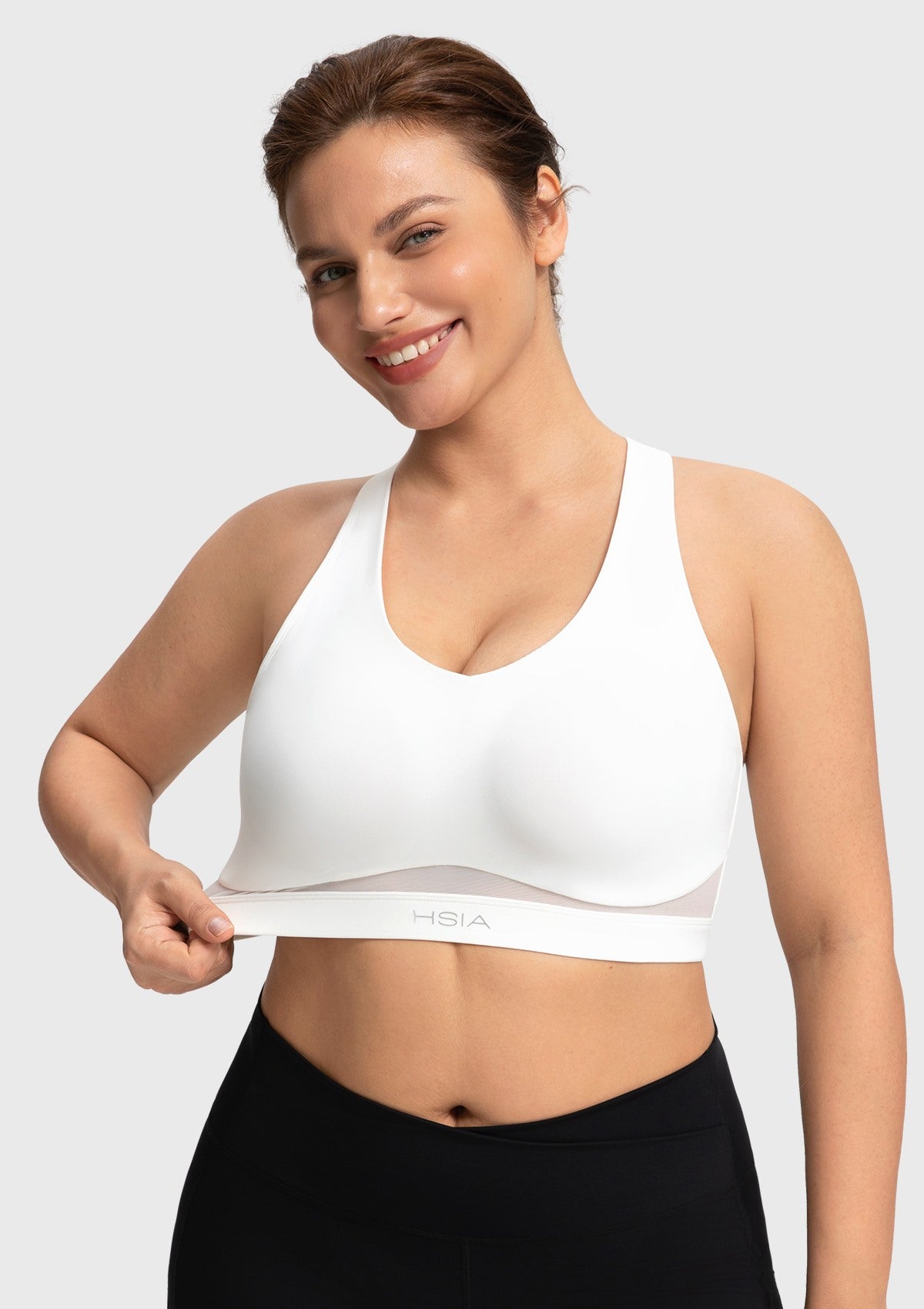 Close-up showing the high-stretch elastic band of the white Aura yoga bra for an inclusive comfortable fit