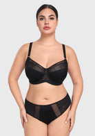 Woman posing confidently in the black French embroidery bra, demonstrating deep cup capacity and a flattering, open neckline without spillage.