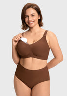 Model holding a breast pump within the cocoa brown supportive nursing bra cup, illustrating the stable hands-free pumping capability for active moms.