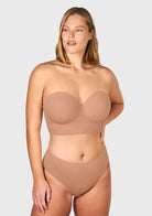 Confident woman wearing the dark beige lightly padded strapless bra, showcasing the secure, anti-slip lift designed for full-busted figures.