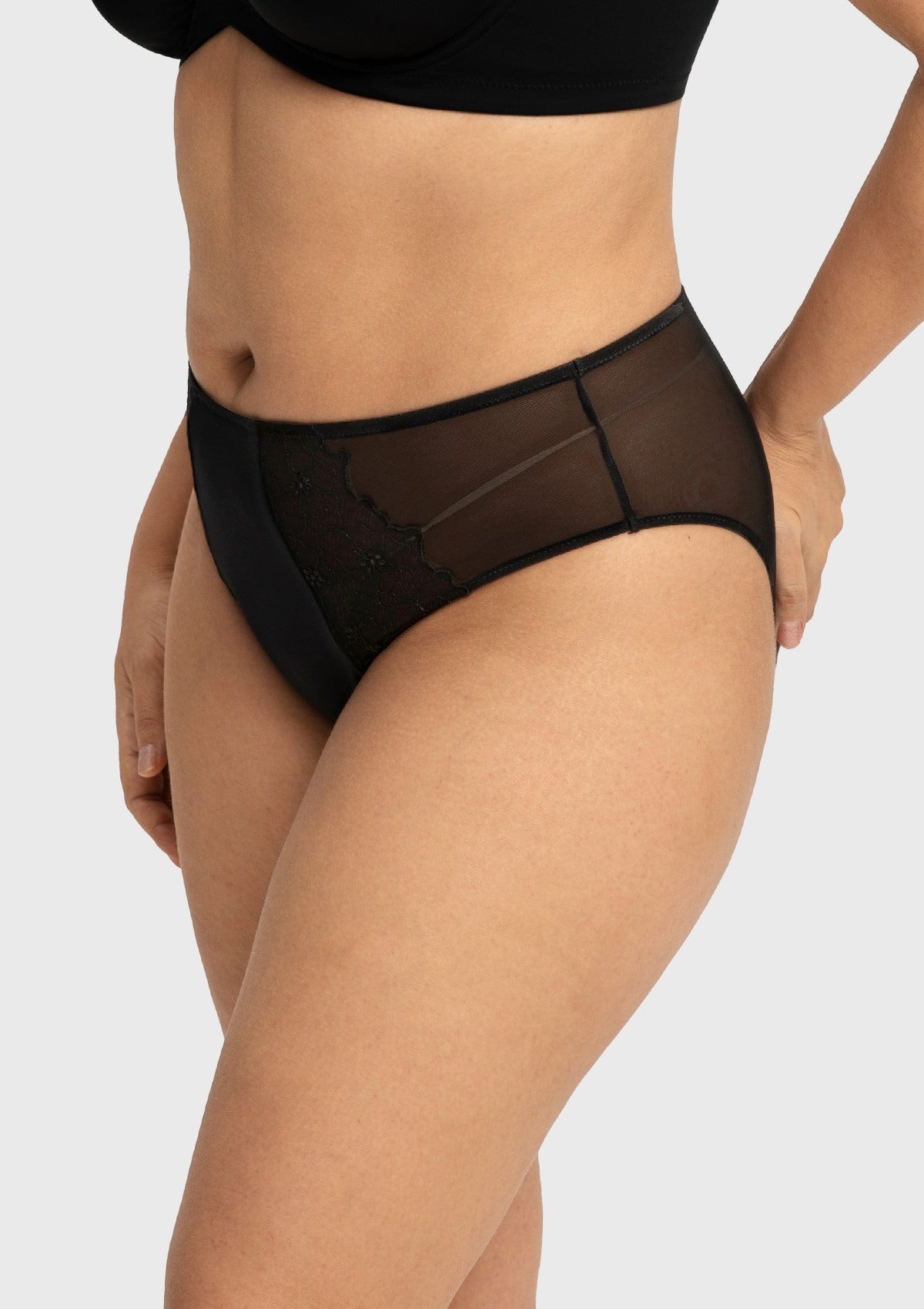 Side profile of model wearing the black Dahlia high waist panty, showcasing the gentle tummy coverage and comfortable stretch fit.