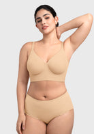 Model raising arms in the beige Delia longline bra, showcasing zero spillage and a secure full coverage fit.