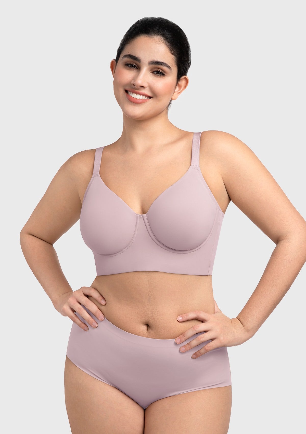 Model lifting arms in the gray purple Delia bra, demonstrating deep full-coverage cups that ensure secure containment.