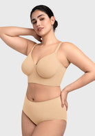Side view with arms raised in the beige Delia bra, emphasizing the wide elastic underband that prevents rolling.