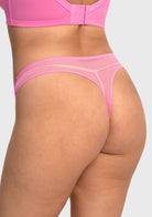 Rear view of model in medium pink high waist lace thong, showcasing a cheeky seamless cut with no visible panty lines under clothes.