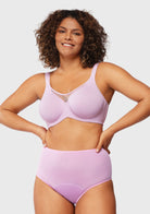 Confident woman with hands on hips in the lavender unlined underwire minimizer bra, demonstrating effortless full coverage shaping and invisible armor.