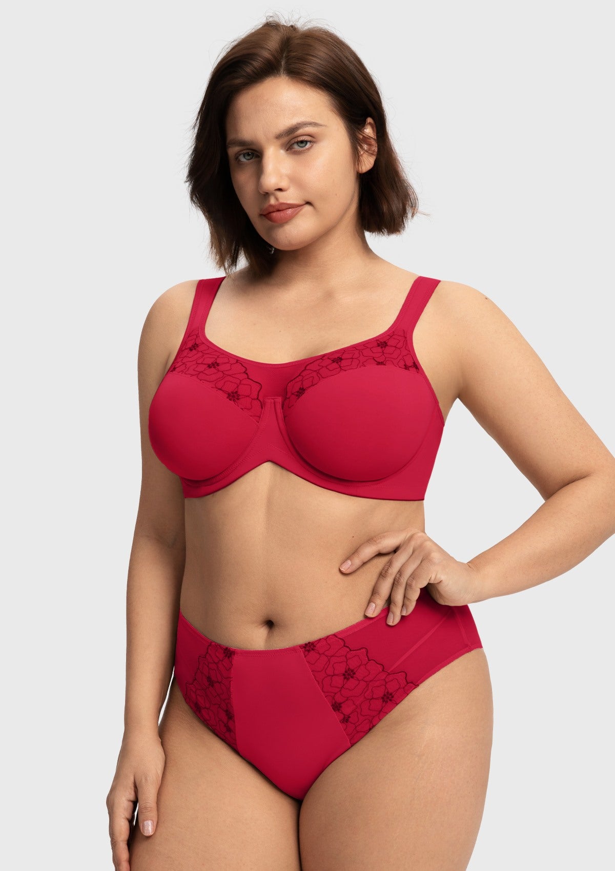 Woman with hands on hips modeling the red supportive unlined lace bra, enjoying a lightweight feel with the unwavering stability of a sports bra.